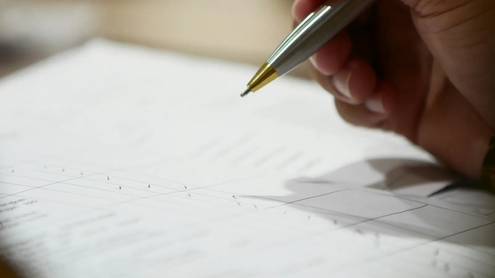 Main tenant un stylo au-dessus d'un formulaire à remplir