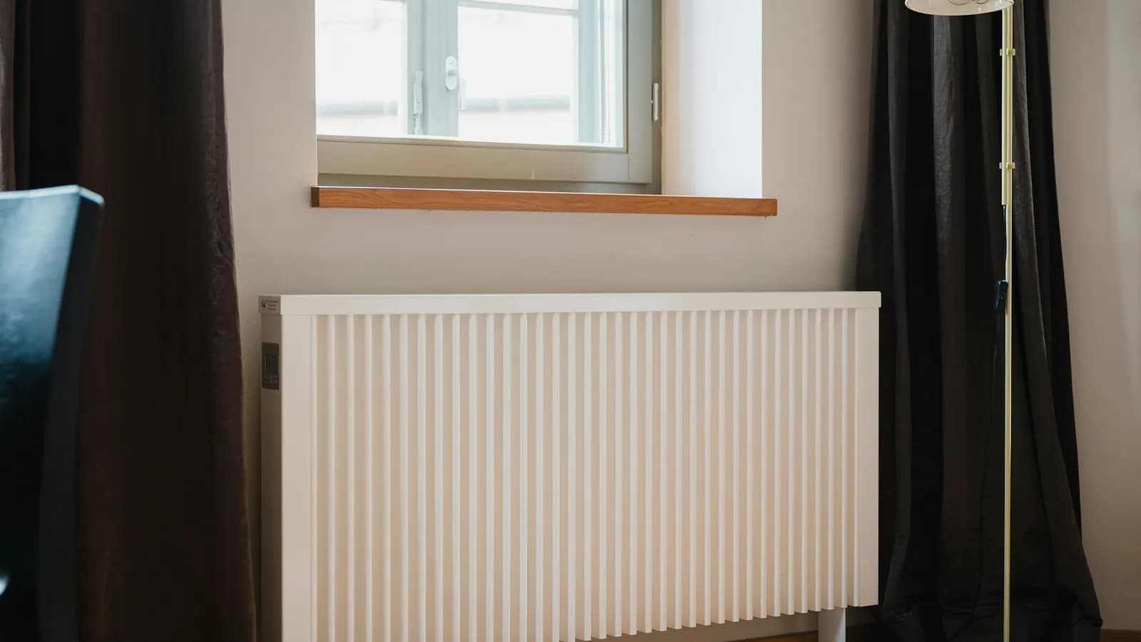 Radiateur blanc sous une fenêtre dans une pièce d'appartement