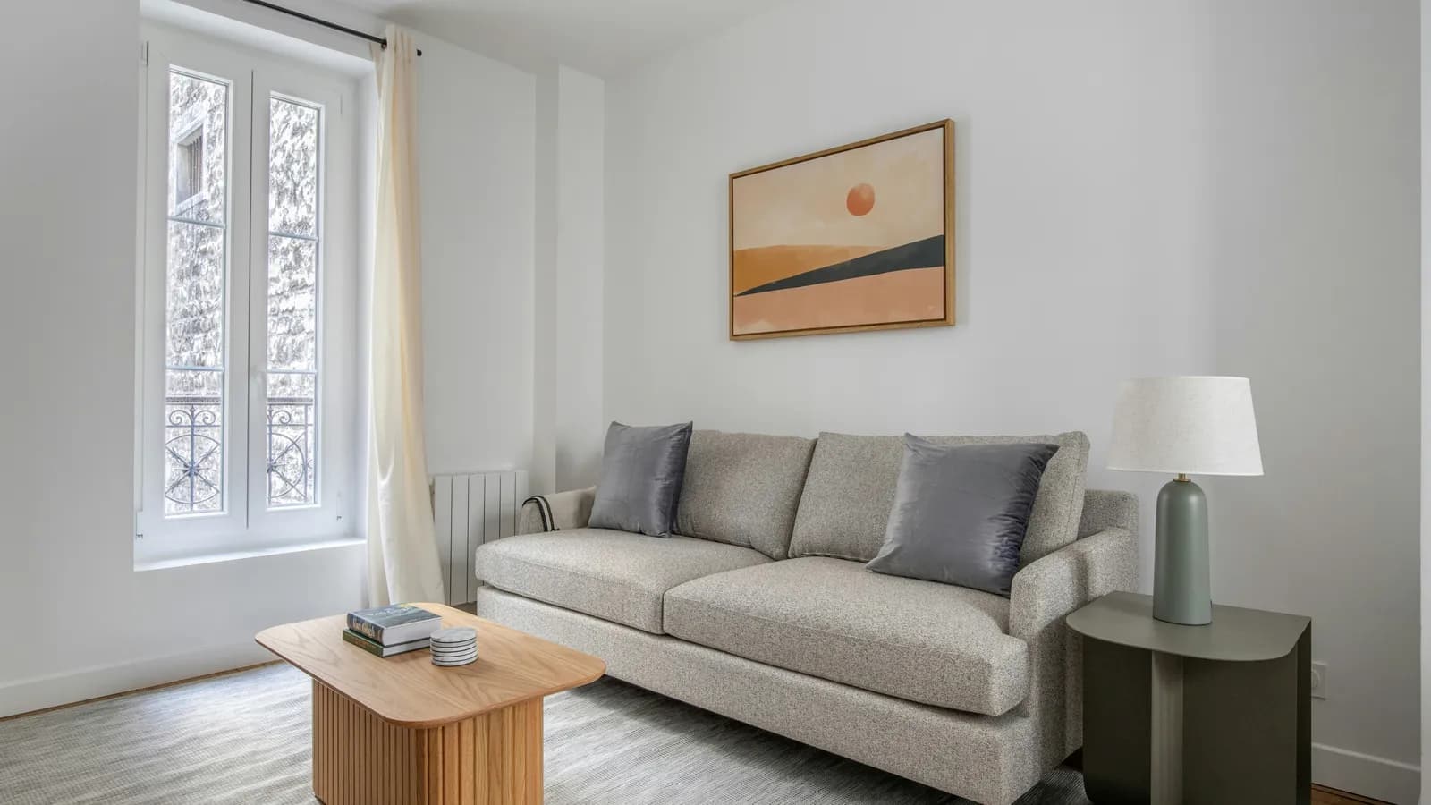 Séjour meublé lumineux avec canapé, table basse et grande fenêtre