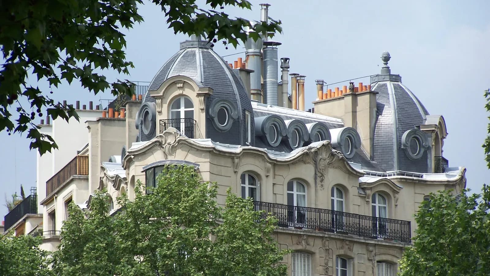 Immeuble haussmannien à dôme et balcons à Paris