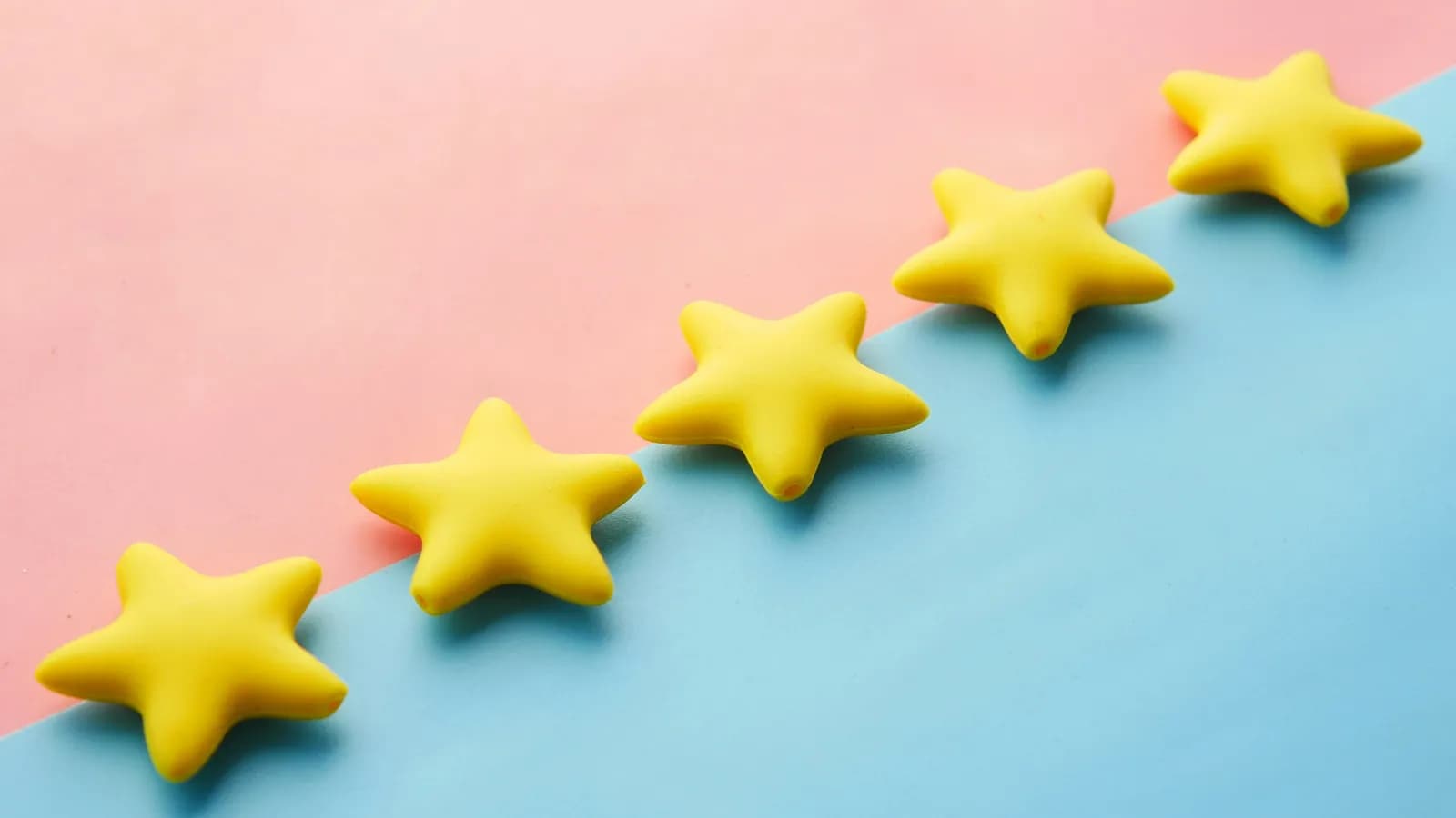 Cinq étoiles jaunes de notation sur fond rose et bleu