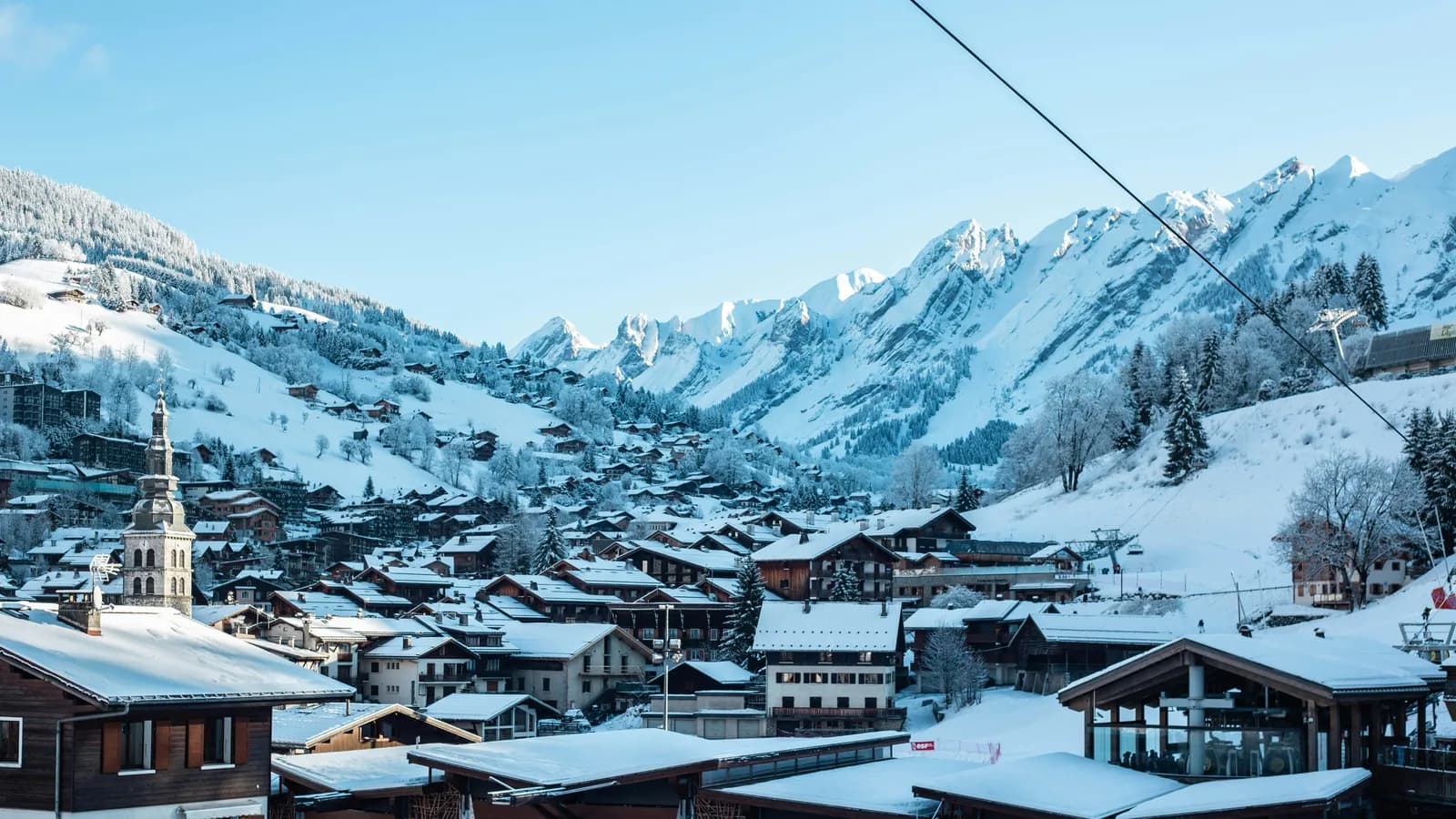 Village de La Clusaz enneigé sous un ciel bleu